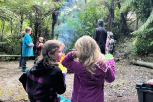 Children talking and bonding outside in front of a campfire at an overnight camp